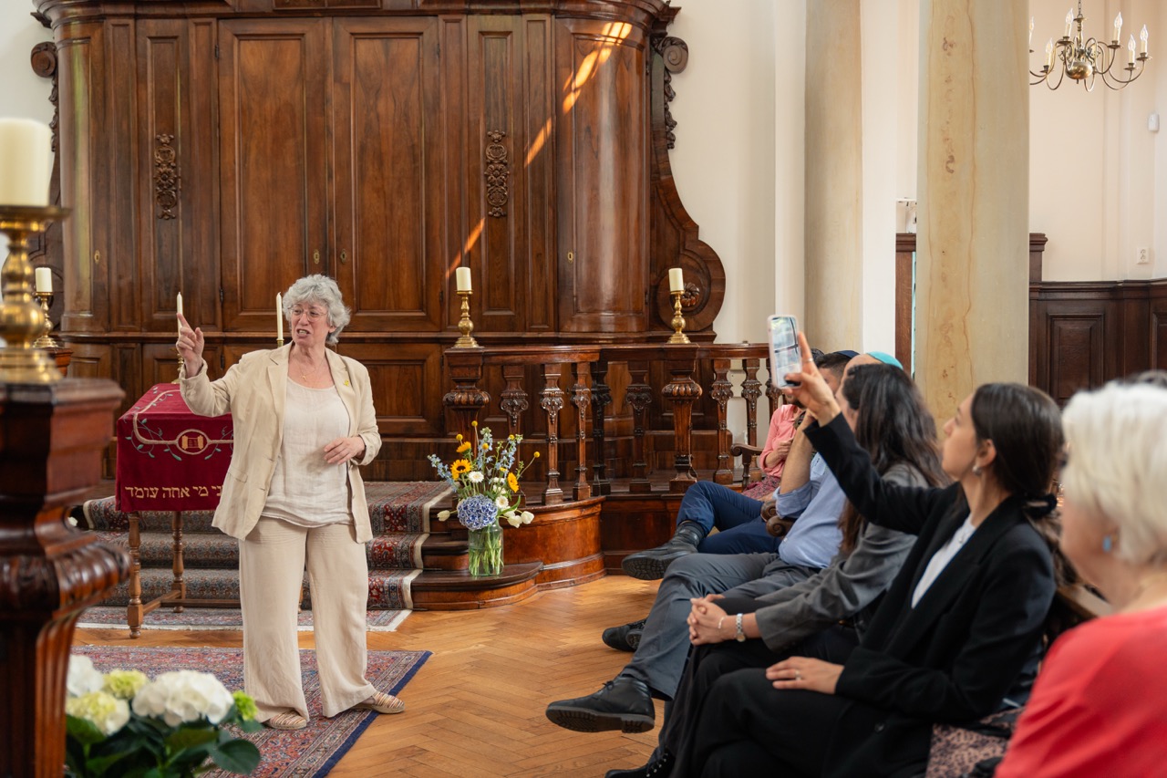 A speaker addressing a seated audience in a historic hall